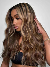 Model wearing Bess wavy brown human hair wig with blonde highlights – side front view